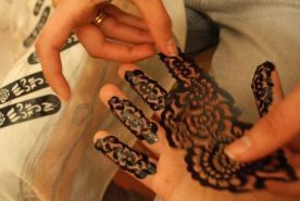 Imel okleja moje dłonie specjalnymi naklejkami w wytłoczonym wzorkiem, następnie nakłada woniejąca ziołami papkę i zawija mi dłonie w chusty Przybieżeli do... Bengasi