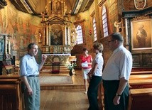 Oprowadzający po kościele (z lewej) Damian Rduch i Agnieszka Franosz razem z ks. Markiem Winiarskim. W tle ołtarz główny z obrazem św. Michała