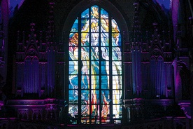  Rozświetlony witraż „Bóg Ojciec” projektu Stanisława Wyspiańskiego sprzyja modlitwie w krakowskim kościele franciszkanów 