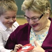 Chwila radości i wzruszenia na twarzy babci i wnuka przy wręczaniu papierowego serca