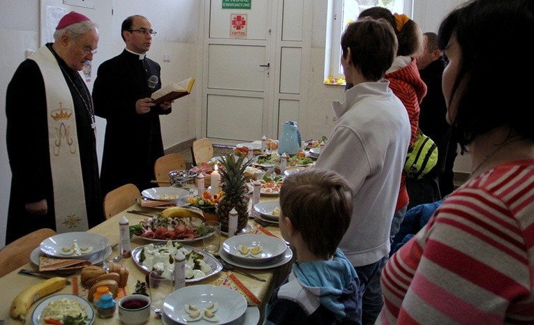 Abp Henryk Hoser i ks. Dariusz Marczak, dyrektor praskiej Caritas witają gości śniadania