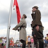 Flagę na maszt wciągają członkowie Muzealnej Grupy Rekonstrukcji Historycznej II Batalionu 18 Pułku Piechoty