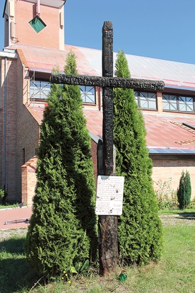 Umieszczony przed wejściem do sanktuarium spalony krzyż przypomina o dawnym zabytkowym kościele 