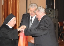 Przewodniczący Stanisław Nycz i burmistrz Marian Trela odbierają dar kard. Jaworskiego dla radnych