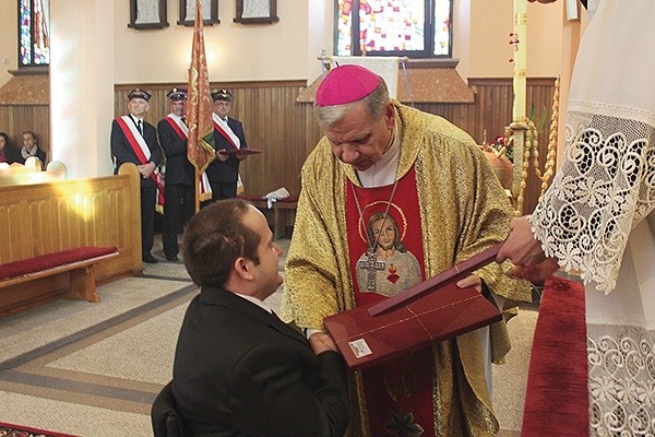  Łukasz Warzecha przyjmuje podziękowania od bp. Jana Kopca za wspieranie inwestycji ofiarą, modlitwą i niesieniem osobistego krzyża 