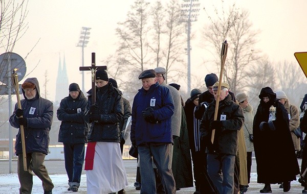 Modlitwa w drodze. W tle wieże bazyliki św. Antoniego i stadion, na którym w 1945 r. zamarzło lub zostało zastrzelonych przez Niemców 385 osób