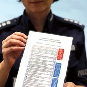 Policjantka prezentuje kwestionariusz, który według ustawy o przeciwdziałaniu przemocy w rodzinie muszą wypełniać interweniujący funkcjonariusze
