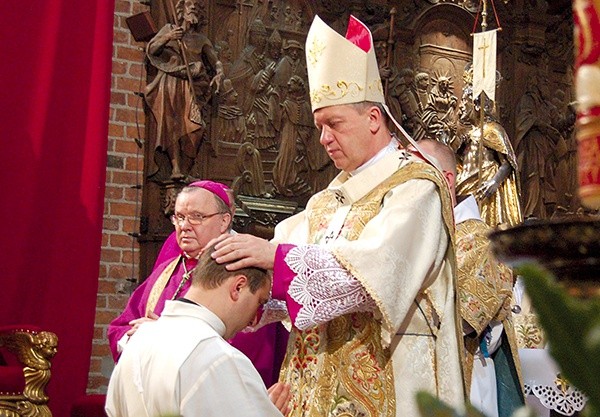 W czasie udzielania święceń biskup nakłada ręce na głowę kandydata  