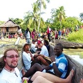  Misjonarz (na pierwszym planie) dopływa do wioski na rzece Sepik