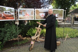 Ks. Jerzy Kraśnicki demonstruje przywieziony z misji w Afryce pojazd: rower z drewna