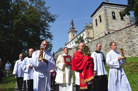 Procesja z relikwiami Drzewa Krzyża Świętego. W tle odbudowana  wieża kościelna