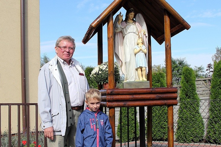 Benedykt Chojnacki z wnukiem Jasiem przy kapliczce, którą wykonali