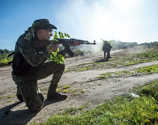 Uczestnicy manewrów obrony terytorialnej ćwiczą obronę  trasy konwoju w terenie 