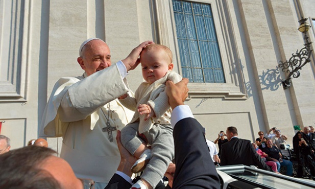  8 października 2014, watykan. Papież Franciszek błogosławi dziecko podane mu przez osobę stojącą w tłumie wiernych w czasie środowej audiencji na placu Świętego Piotra. W Watykanie trwa synod o rodzinie.