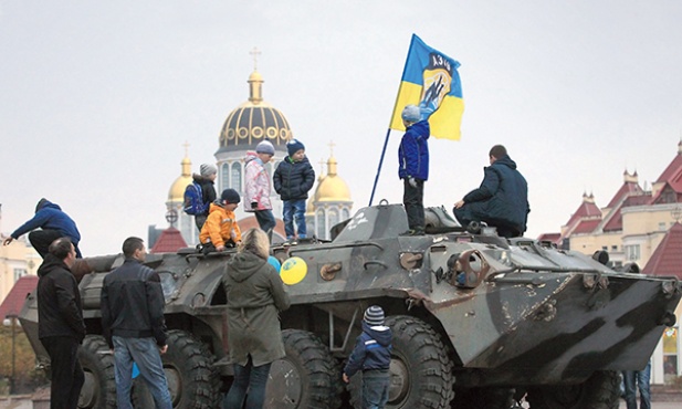 Ukraina, 21 października 2014. Dzieci bawią się na wozie bojowym przejętym przez Ukraińców na linii frontu na wschodzie kraju.  W Kijowie zorganizowano prezentację zdobytych pojazdów wojskowych.