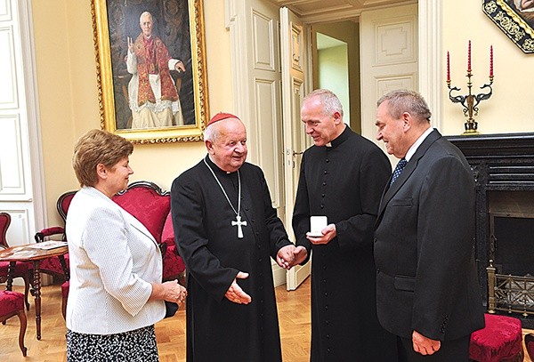   Kard. S. Dziwisz przekazuje relikwie ks. B. Karpowi i państwu Budkom