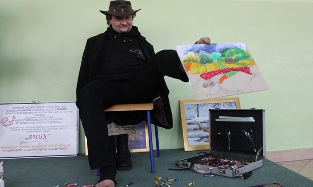 Stanisław Kmiecik z pejzażem, który namalował dla uczniów bielskiego Gimnazjum nr 13 w czasie spotkania z nimi