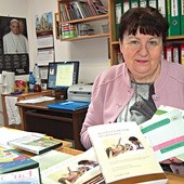  Małgorzata Górka pokazuje książki, które można wypożyczyć w ich ośrodku