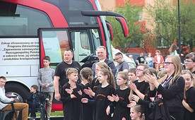  Ks. Robert Kowalski razem z wolontariuszami oklaskuje występ młodzieżowej orkiestry. W tle krwiobus