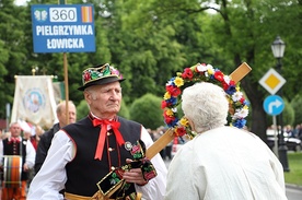 Mieszkanka Łowicza całuje pielgrzymkowy krzyż