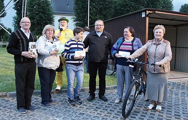 Szczęśliwi zwycięzcy parafialnego losowania nagród z ks. Jerzym Matogą i konferansjerem Janem Chmielem