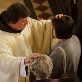 Kapłan modli się o uzdrowienie chorych