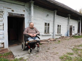 Piotr Sikora przed swoim domem wymagającym pilnego remontu