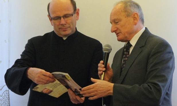 Jan Rejczak pokazuje okolicznościowy biuletyn ks. Krzysztofowi Ćwiekowi, proboszczowi radomskiej katedry