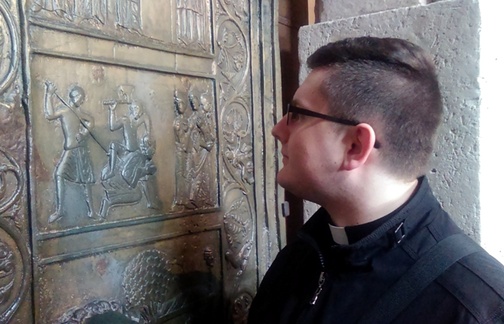 Al. Mateusz Czernik przypatruje się scenie śmierci św. Wojciecha przedstawionej na drzwiach gnieźnieńskich