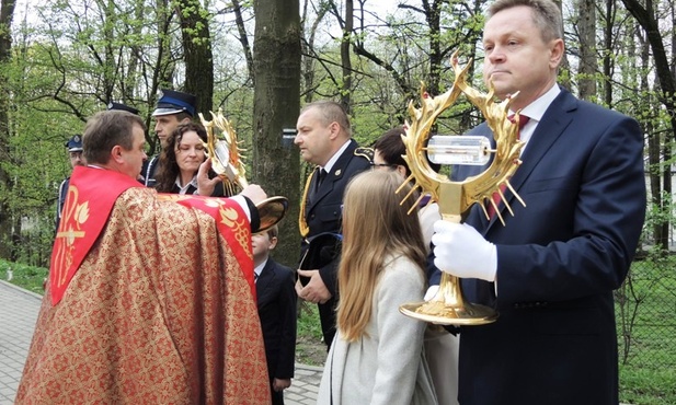 Ks. Stanisław Filapek podaje rodzinom parafii peregrynujące relikwie do uczczenia
