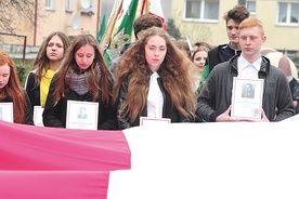 Uczniowie podczas marszu nieśli zdjęcia ofiar katyńskich, których Dęby Pamięci posadzono w Ostródzie