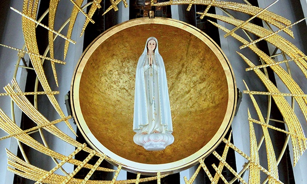 Figura MB Fatimskiej  w prezbiterium otoczona jest tzw. wirującym słońcem.
