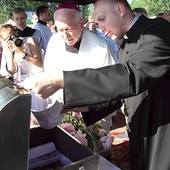 Bp Andrzej F. Dziuba i ks. Rafał Babicki zaglądają do metalowej skrzyni.