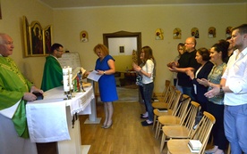 Dorota Rędzia (w środku) odbiera dyplom z rąk ks. Andrzeja Jędrzejewskiego