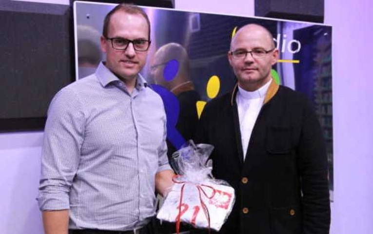 Pan Jacek odbiera koszulkę Bartosza Kapustki, wygraną podczas licytacji. Z prawej ks. Jacek Miszczak, dyrektor radia RDN