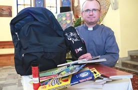 Ks. Marcin Płaneta z Dębicy-Latoszyna prezentuje zawartość wypełnionych plecaków.