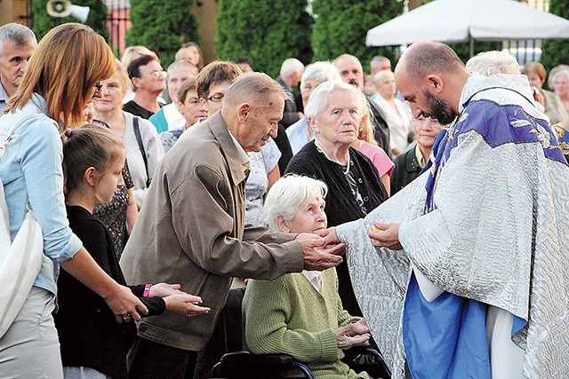 ▲	Ks. Krzysztof Osiński całuje krzyż pielgrzymkowy jednej z wiosek swojej parafii. 