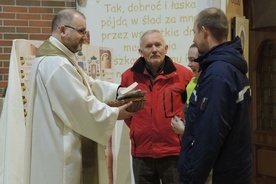 Szczęśliwcy, którzy odpowiedzili prawidłowo na roratnie pytanie i zostali wylosowani, odbierają nagrody z rąk ks. Przemysława Sawy