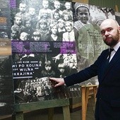 ▲	Historyk wskazuje zawarte na wystawowych panelach tragiczne losy dzieci ze szkoły w Zagajach.