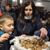 Uczestnicy liturgii zabierają pobłogosławione orzechy do domu