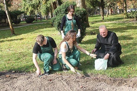 Ks. Robert Kowalski pomagał uczniom przy sadzeniu cebulek żonkili.