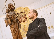 Ksiądz Marcin Gołębiewski i dębowa figurka św. Józefa z Dzieciątkiem.