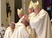 ▲	Moment nałożenia rąk na biskupów pomocniczych. 