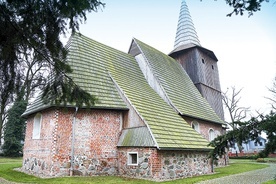 ▲	Nad kamienno-ceglaną bryłą kościoła góruje drewniana wieża, przykryta wysokim hełmem. 