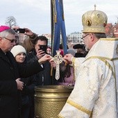 Jednym z elementów obrzędu jest zanurzenie w wodzie krzyża.