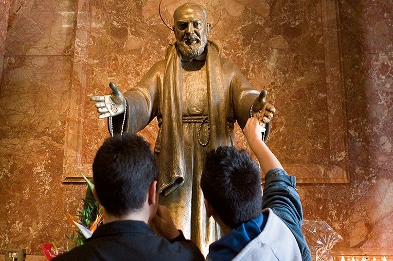 Pielgrzymi przed figurą św. ojca Pio w kościele S. Maria delle Grazie w San Giovanni Rotondo.
