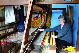 . ◄	Halina Witkowska, prezes stowarzyszenia, przy dawnej maszynie tkackiej. 