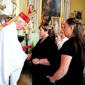 Biskup Dziuba wręcza pamiątkowy grawerton mamie  śp. Michała Wieczorka.