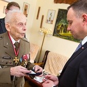 Gen. Tadeusz Bieńkowicz przekazuje prezydentowi Andrzejowi Dudzie więzienny krzyżyk.