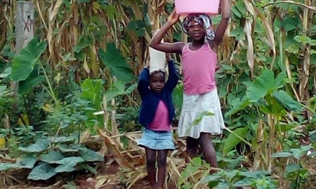 Dzieci noszą wodę do domów